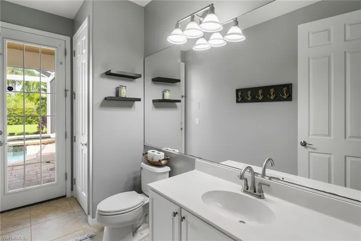 Bathroom with vanity, toilet, a chandelier, and tile patterned floors