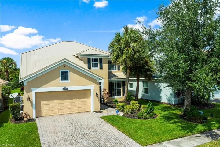 View of front of property featuring a garage and a front lawn