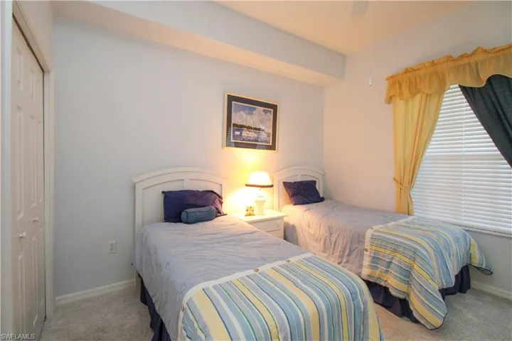 Carpeted bedroom with a closet