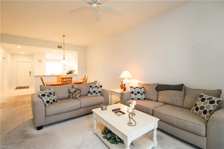 Living room featuring light colored carpet and ceiling fan
