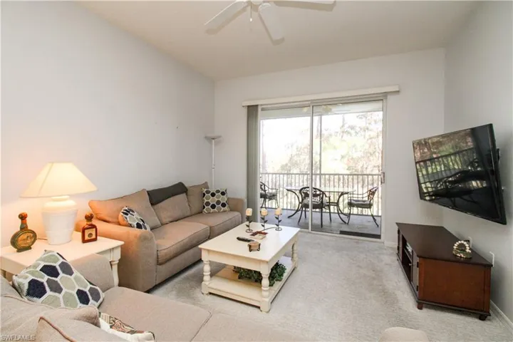 Living room featuring light carpet and ceiling fan
