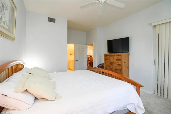 Bedroom with carpet flooring, ceiling fan, and ensuite bathroom