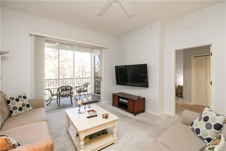Living room with ceiling fan and light colored carpet