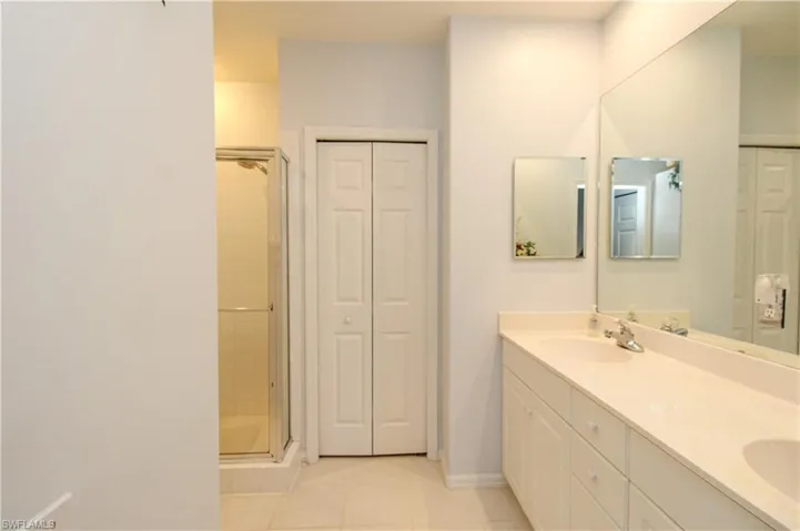 Bathroom featuring tile patterned flooring, vanity, and an enclosed shower