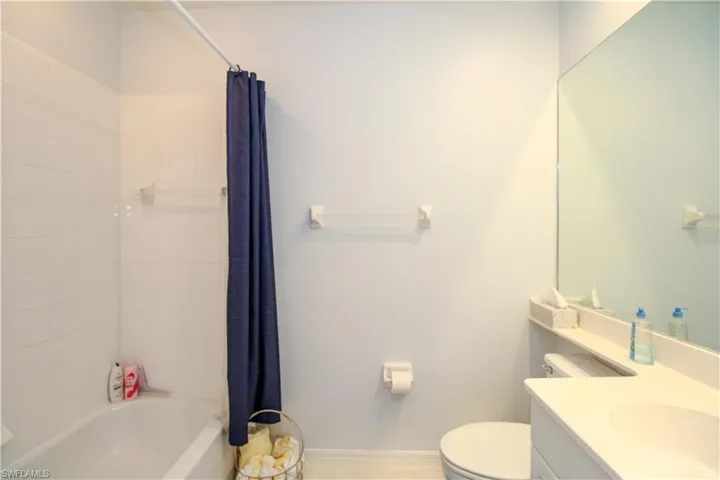 Full bathroom featuring shower / tub combo with curtain, vanity, and toilet