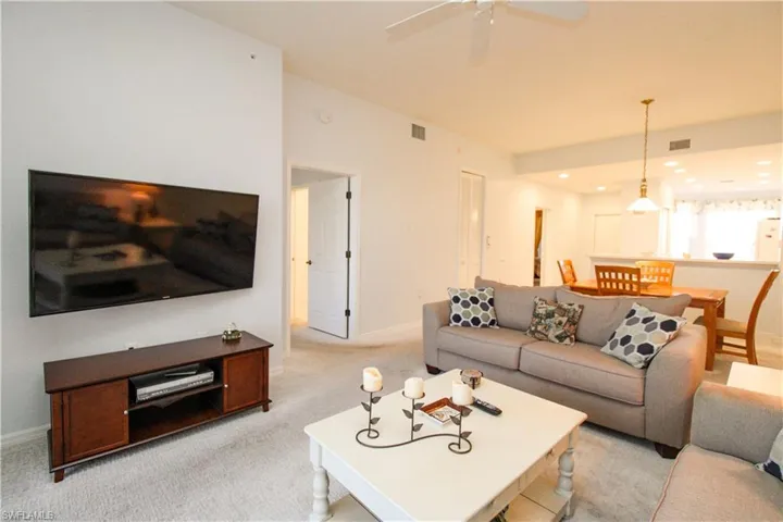 Carpeted living room with ceiling fan