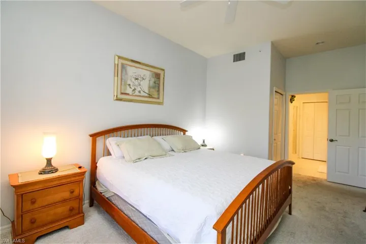 Carpeted bedroom with a closet and ceiling fan