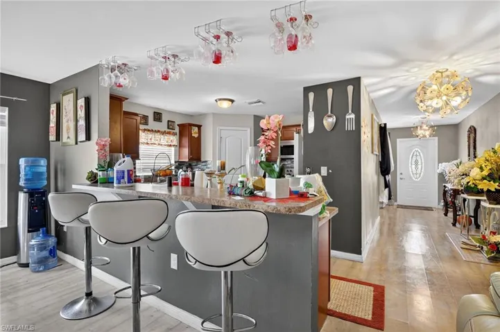Kitchen featuring a breakfast bar, a peninsula, brown cabinetry, and light wood-style flooring