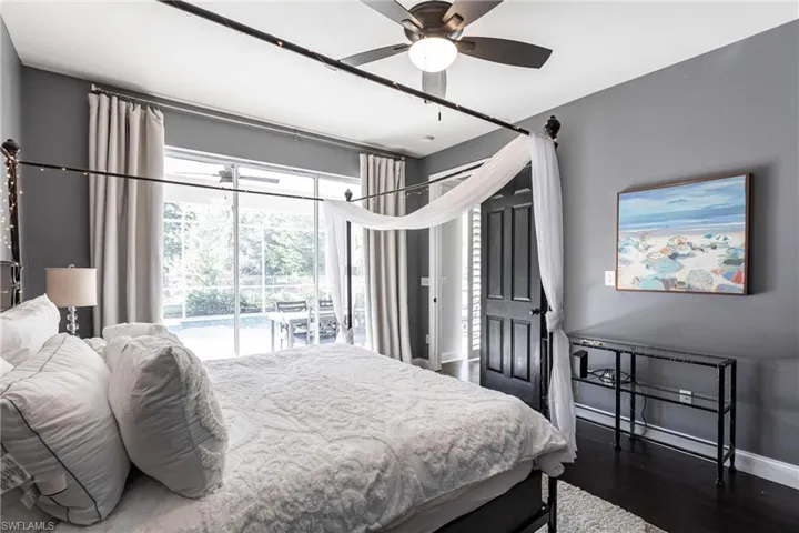 Bedroom featuring access to exterior, dark hardwood / wood-style flooring, and ceiling fan
