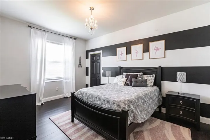 Bedroom featuring a notable chandelier and hardwood / wood-style flooring