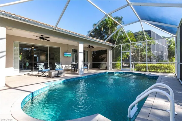 View of swimming pool featuring a lanai, ceiling fan, and a patio area