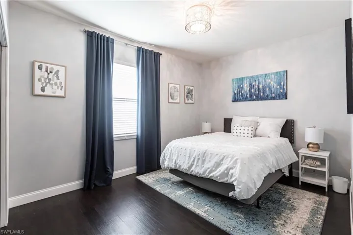 Bedroom featuring dark hardwood / wood-style flooring and a chandelier