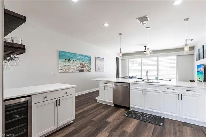 Kitchen with pendant lighting, dishwasher, sink, and beverage cooler