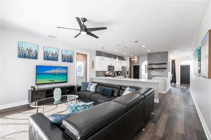 Living room with dark hardwood / wood-style floors and ceiling fan