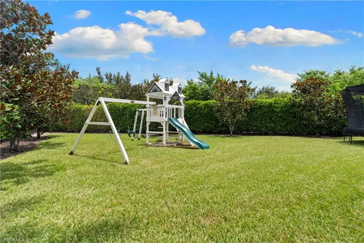 Expansive green lawn with mature perimeter hedging