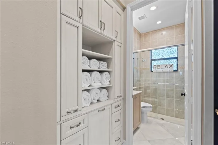 Built-in white cabinetry with open shelving and storage
