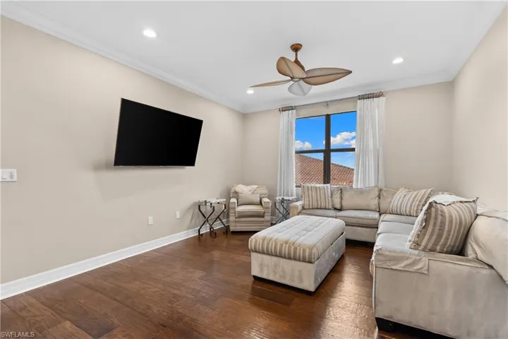 Living area featuring wood-finish flooring, recessed lighting, and a ceiling fan