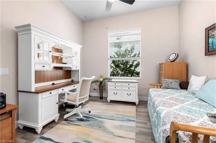 Bedroom featuring ceiling fan and dark wood-type flooring