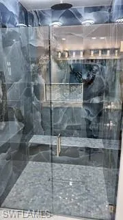Full bath featuring a marble finish shower
