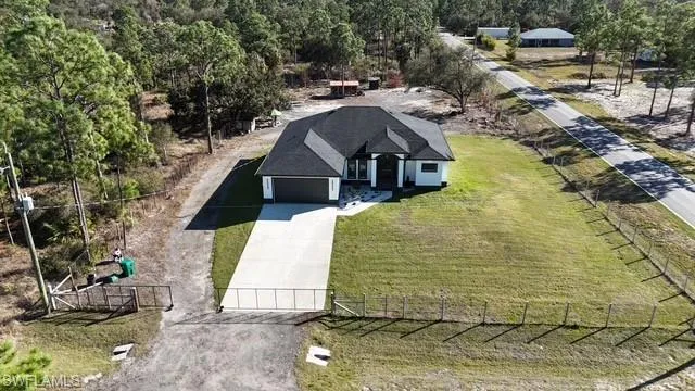 Aerial view of property and surrounding area with a forest
