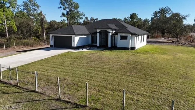 View of front of house featuring concrete driveway, an attached garage, and stucco siding