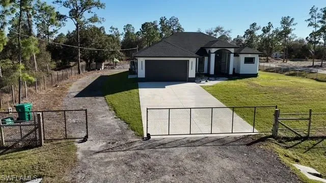 View of front of home featuring a fenced front yard, a gate, concrete driveway, stucco siding, and an attached garage