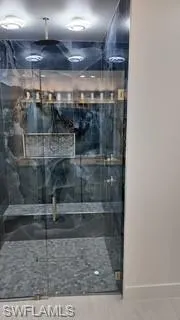 Full bathroom with a marble finish shower