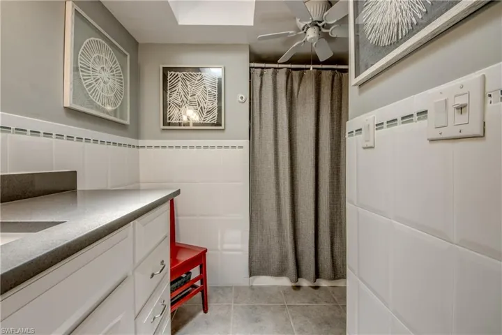 Bathroom with tile patterned floors, vanity, and ceiling fan