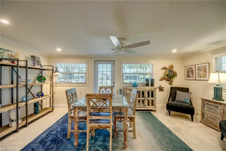 Dining space with ornamental molding, light tile patterned floors, ceiling fan, and plenty of natural light