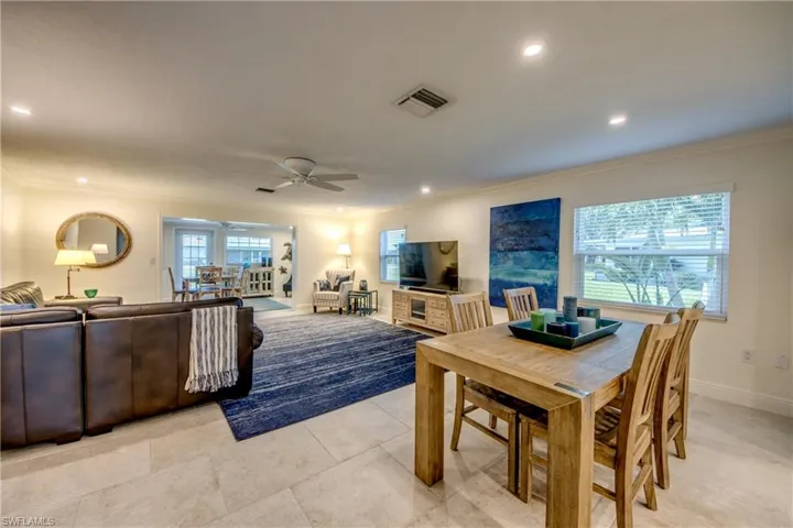 Dining room featuring light tile patterned flooring, a healthy amount of sunlight, crown molding, and ceiling fan