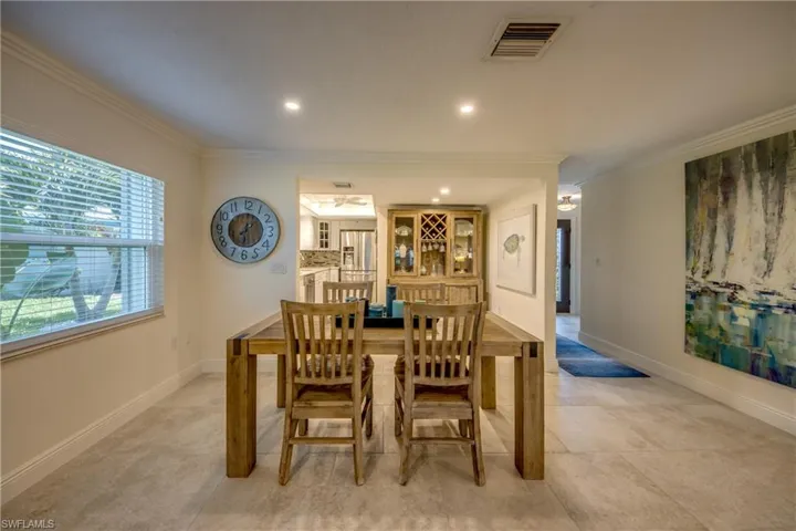 Tiled dining space featuring crown molding