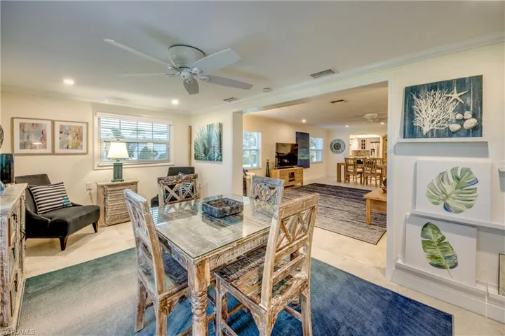 Dining room with tile patterned floors, ornamental molding, and ceiling fan