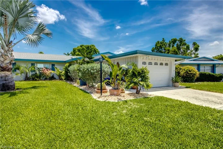 Ranch-style home featuring a garage and a front yard