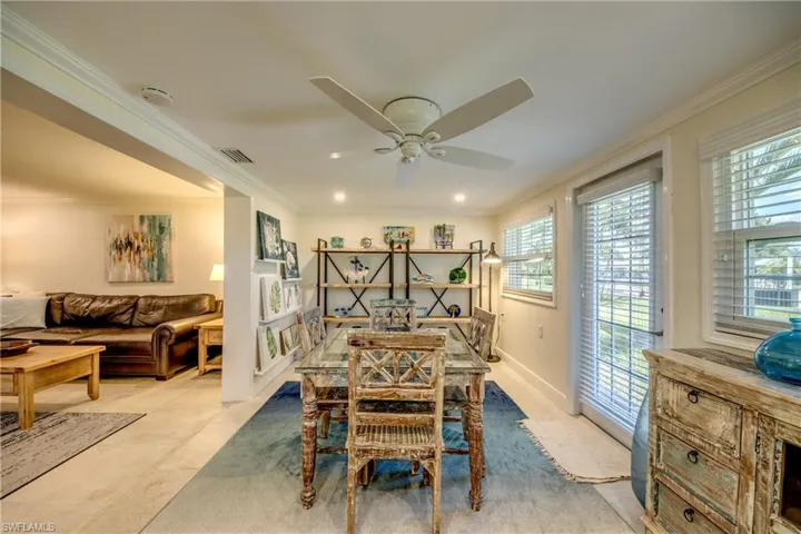Tiled dining space featuring ornamental molding and ceiling fan