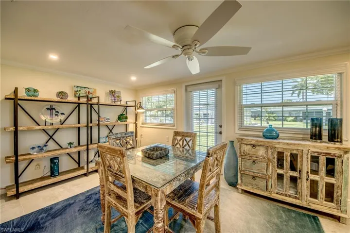 Tiled dining space with crown molding, ceiling fan, and a healthy amount of sunlight