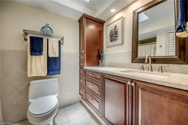 Bathroom featuring tile walls, tile patterned floors, crown molding, and vanity