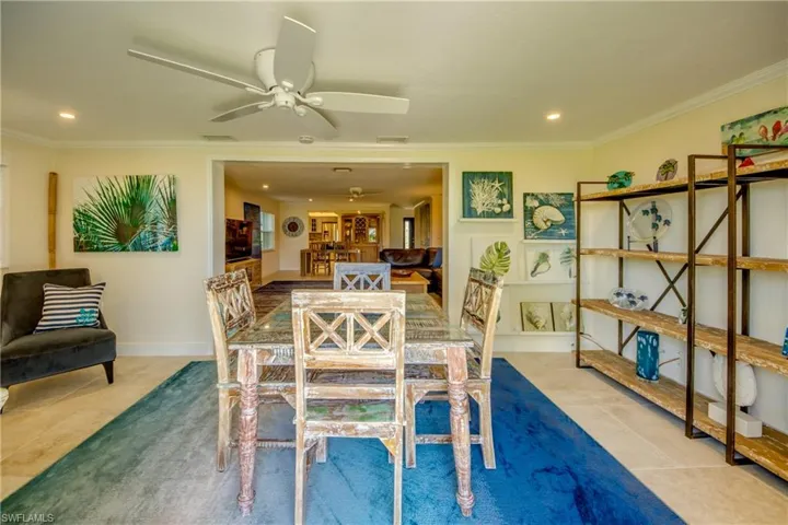 Dining room with ornamental molding, tile patterned floors, and ceiling fan