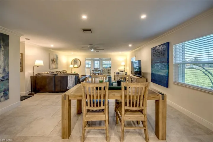 Dining room featuring ornamental molding, light tile patterned flooring, and ceiling fan