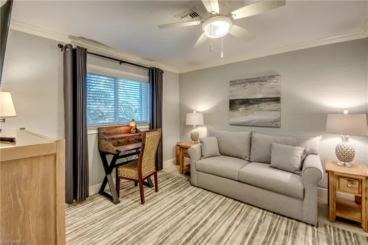Living room featuring ornamental molding and ceiling fan