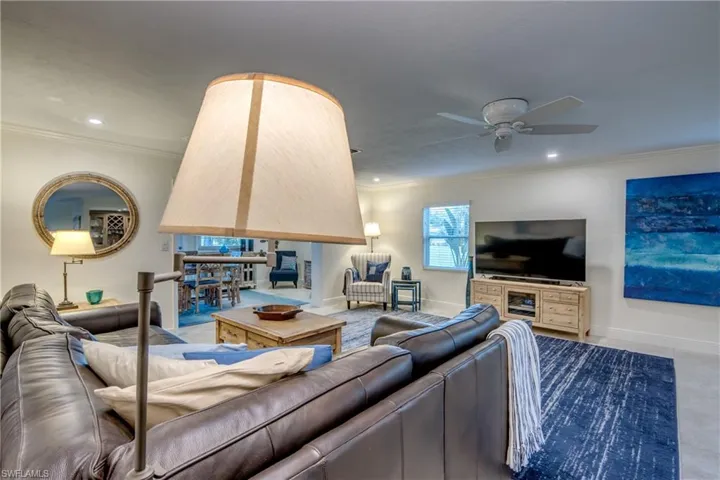 Living room featuring crown molding and ceiling fan