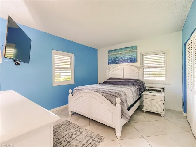 Bedroom with light tile patterned floors, a textured ceiling, and a closet
