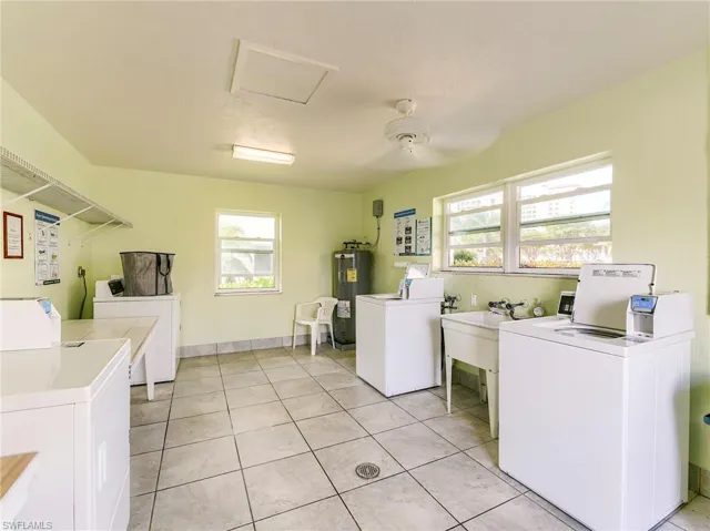 Communal laundry room featuring separate washer and dryer and water heater