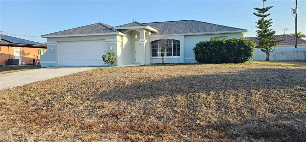 Single story home with stucco siding, a garage, concrete driveway, and a front yard