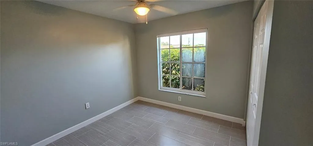 Unfurnished room with baseboards and a ceiling fan