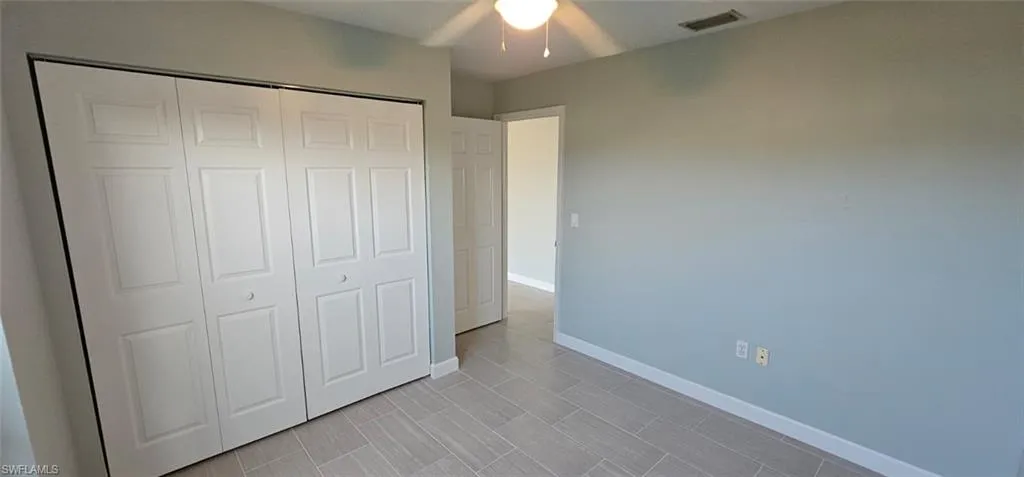 Unfurnished bedroom featuring a closet, ceiling fan, and wood tiled floors