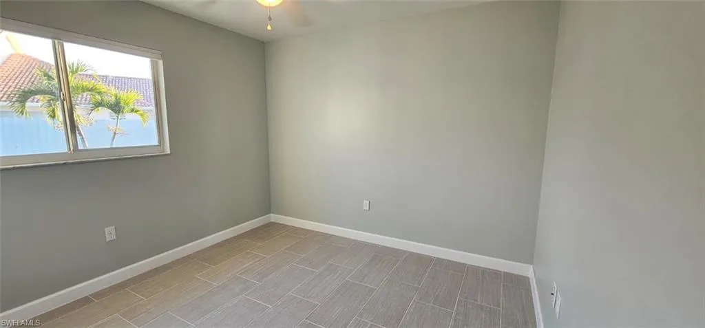 Empty room with a ceiling fan and wood finish floors