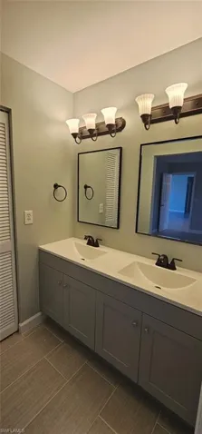 Bathroom featuring double vanity and a closet