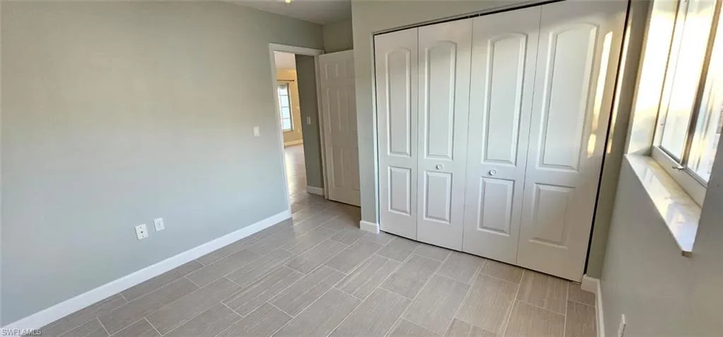Unfurnished bedroom with a closet and wood finish floors