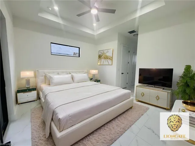 Bedroom featuring a tray ceiling and ceiling fan. This room has been virtually staged