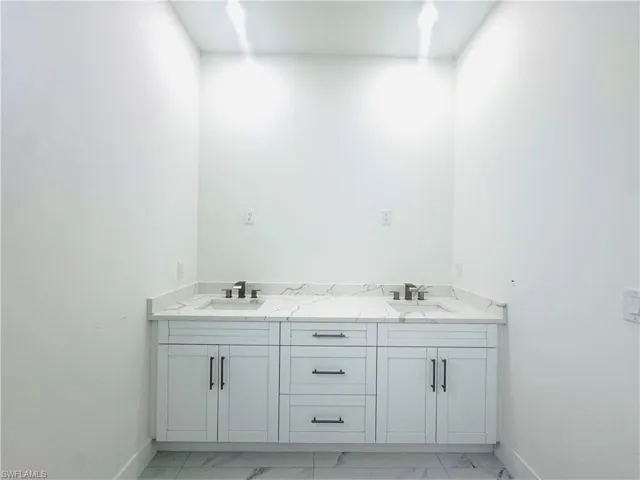 Full bathroom with double vanity and light marble finish floors. More upgrades to come in this bathroom.